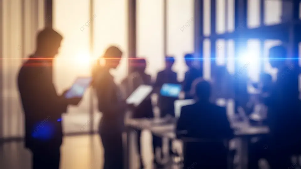 Sagome sfocate di professionisti che usano tablet e laptop in un ufficio moderno e luminoso.